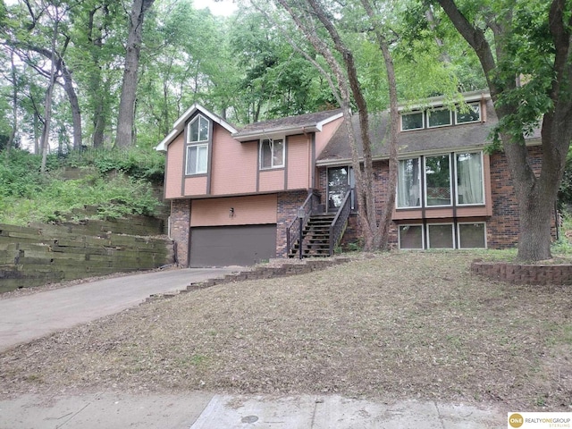 826 Hidden Hills Dr, Bellevue, NE 68005 - split level home with brick siding, driveway, an attached garage, and stairs