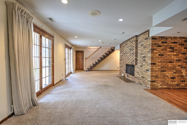 1915 S 131st Ave, Omaha, NE 68144 - unfurnished living room with brick wall, carpet flooring, a brick fireplace, recessed lighting, and stairway
