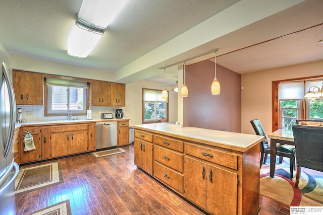 1915 S 131st Ave, Omaha, NE 68144 - kitchen with stainless steel appliances, brown cabinetry, dark wood-style floors, light countertops, and a textured ceiling