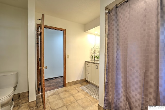 1915 S 131st Ave, Omaha, NE 68144 - full bathroom featuring toilet, stone tile flooring, vanity, and baseboards