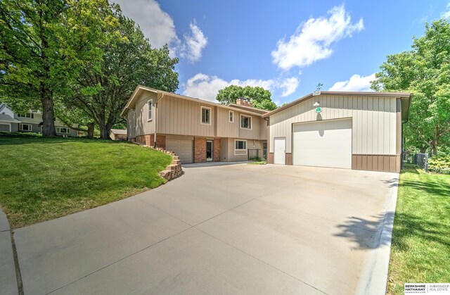 1915 S 131st Ave, Omaha, NE 68144 - view of front of house with a garage, brick siding, a front lawn, and driveway