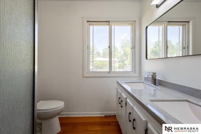 1511 Lorraine Ave, Bellevue, NE 68005 - bathroom with toilet, wood finished floors, baseboards, and double vanity