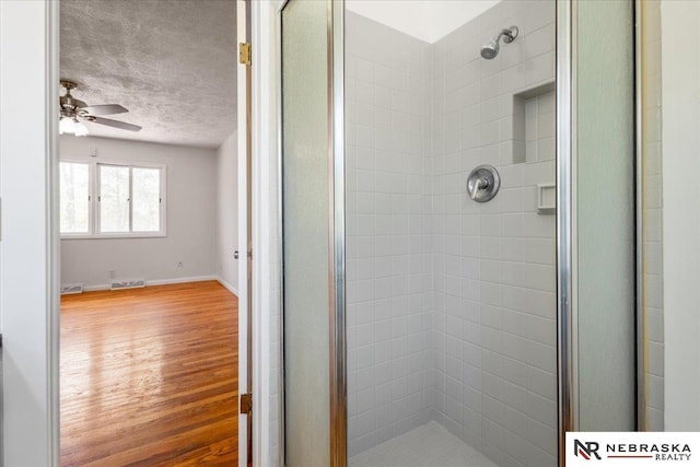 1511 Lorraine Ave, Bellevue, NE 68005 - bathroom featuring a shower stall, wood finished floors, ceiling fan, a textured ceiling, and baseboards