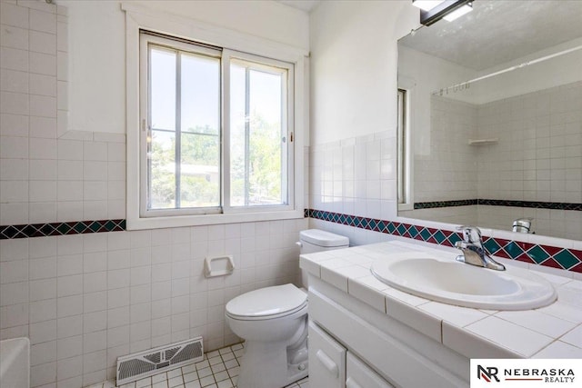 1511 Lorraine Ave, Bellevue, NE 68005 - bathroom with vanity, tile walls, toilet, a shower, and tile patterned flooring