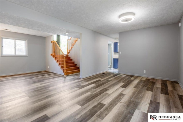 1511 Lorraine Ave, Bellevue, NE 68005 - spare room with a textured ceiling, wood finished floors, stairway, and baseboards