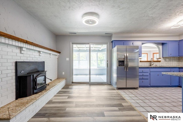 1511 Lorraine Ave, Bellevue, NE 68005 - kitchen with stainless steel fridge with ice dispenser, blue cabinets, a textured ceiling, light wood finished floors, and a sink