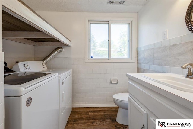 1511 Lorraine Ave, Bellevue, NE 68005 - bathroom with tile walls, washer and dryer, toilet, wood finished floors, and vanity