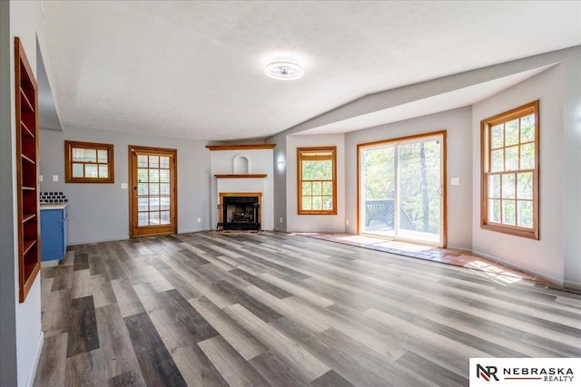 1511 Lorraine Ave, Bellevue, NE 68005 - unfurnished living room with wood finished floors, healthy amount of natural light, a fireplace with flush hearth, lofted ceiling, and baseboards