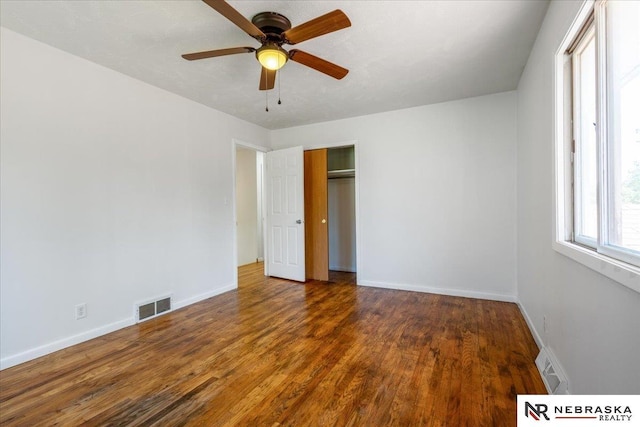 1511 Lorraine Ave, Bellevue, NE 68005 - unfurnished bedroom with wood finished floors, baseboards, a closet, and a ceiling fan