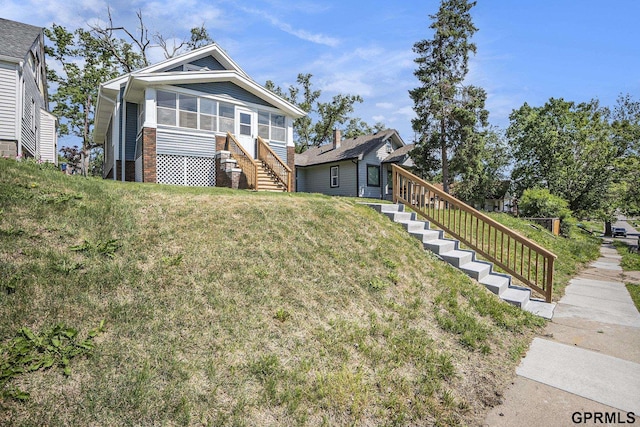 4315 N 39th St, Omaha, NE 68111 - view of front of house with stairway, a front yard, and a sunroom