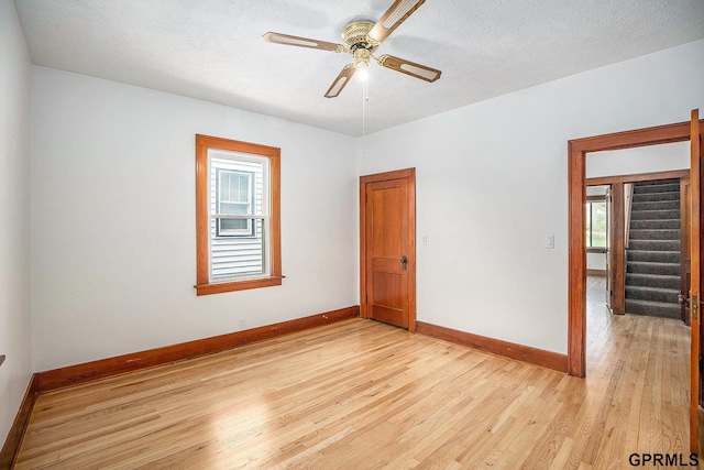 4315 N 39th St, Omaha, NE 68111 - empty room with ceiling fan, baseboards, light wood finished floors, and a textured ceiling