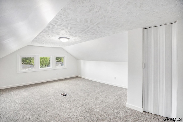 4315 N 39th St, Omaha, NE 68111 - bonus room featuring a textured ceiling, baseboards, vaulted ceiling, and carpet flooring