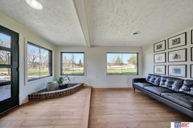 209 N Maloney Dr, North Platte, NE 69101 - living area with baseboards, a textured ceiling, hardwood / wood-style floors, and beam ceiling