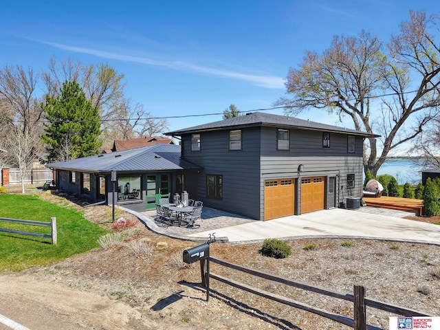 209 N Maloney Dr, North Platte, NE 69101 - back of house featuring an attached garage, driveway, central air condition unit, and a patio area