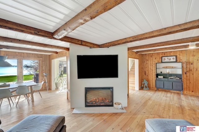 209 N Maloney Dr, North Platte, NE 69101 - living area with wooden walls, beam ceiling, light wood-style flooring, and a glass covered fireplace