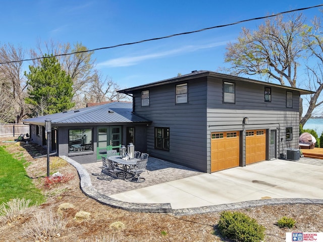 209 N Maloney Dr, North Platte, NE 69101 - rear view of house featuring an attached garage, concrete driveway, a patio, and cooling unit
