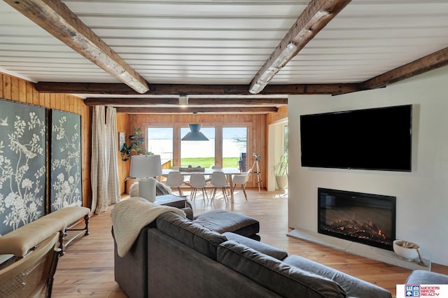 209 N Maloney Dr, North Platte, NE 69101 - living area featuring beamed ceiling, light wood-style floors, a glass covered fireplace, and wood walls
