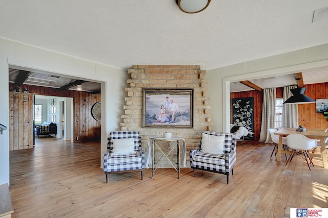 209 N Maloney Dr, North Platte, NE 69101 - living area with wood walls, hardwood / wood-style flooring, a textured ceiling, and ornamental molding