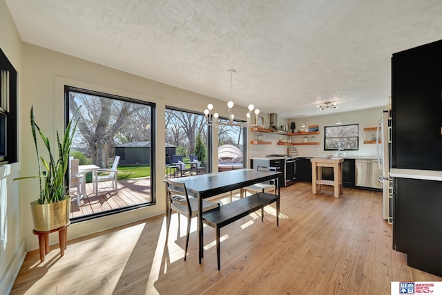 209 N Maloney Dr, North Platte, NE 69101 - dining area featuring plenty of natural light, a chandelier, light wood-type flooring, and a textured ceiling