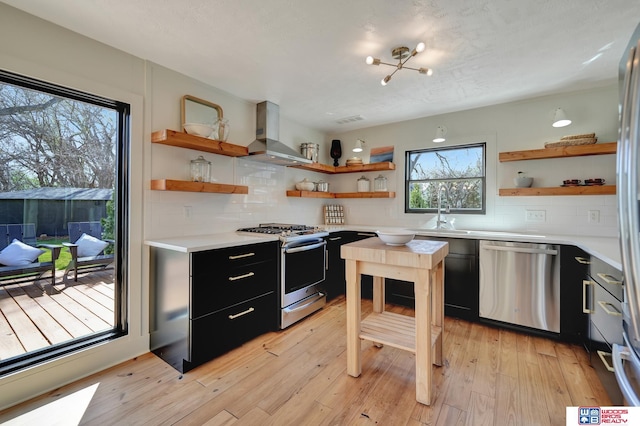 209 N Maloney Dr, North Platte, NE 69101 - kitchen featuring open shelves, appliances with stainless steel finishes, and wall chimney exhaust hood