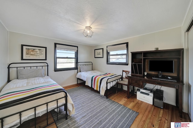 209 N Maloney Dr, North Platte, NE 69101 - bedroom with wood finished floors, a textured ceiling, crown molding, and baseboards