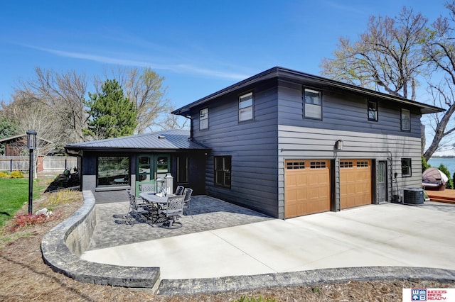 209 N Maloney Dr, North Platte, NE 69101 - rear view of house with a garage, cooling unit, driveway, a patio, and brick siding