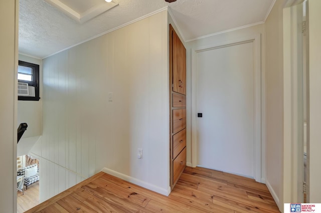209 N Maloney Dr, North Platte, NE 69101 - hallway featuring light wood-style flooring, crown molding, a textured ceiling, and baseboards