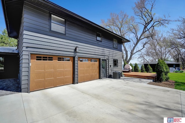 209 N Maloney Dr, North Platte, NE 69101 - view of home's exterior with a garage, driveway, a wooden deck, and central AC unit
