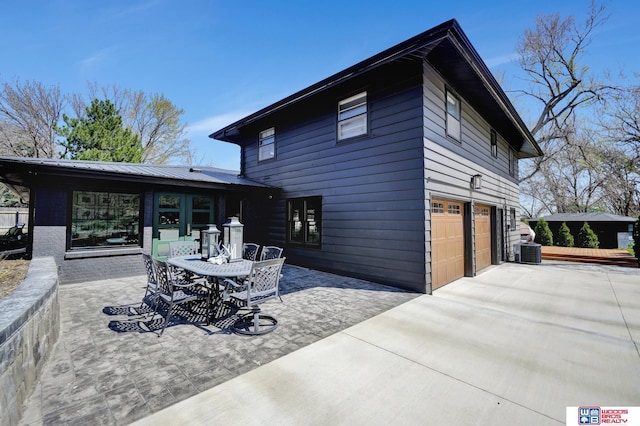 209 N Maloney Dr, North Platte, NE 69101 - back of property with concrete driveway, a garage, central air condition unit, and a patio area
