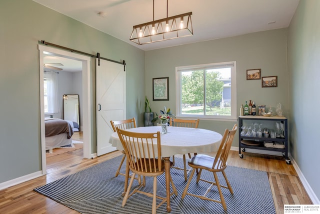 4332 Vinton St, Omaha, NE 68105 - dining space featuring a barn door, light wood-style floors, and baseboards
