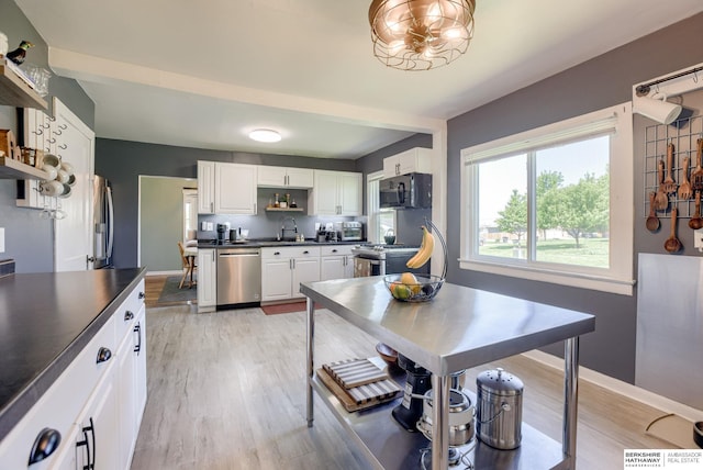 4332 Vinton St, Omaha, NE 68105 - kitchen featuring appliances with stainless steel finishes, open shelves, dark countertops, a sink, and white cabinetry