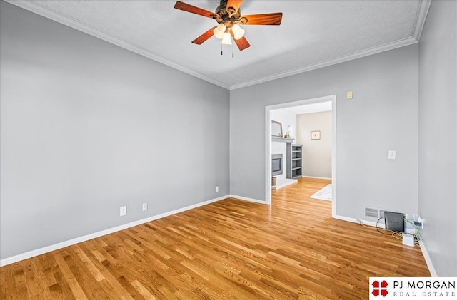 5517 S 174th Ave, Omaha, NE 68135 - unfurnished room featuring light wood-type flooring, ceiling fan, crown molding, baseboards, and a fireplace with raised hearth
