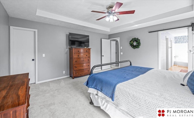5517 S 174th Ave, Omaha, NE 68135 - bedroom with a tray ceiling, light carpet, baseboards, ceiling fan, and ensuite bath