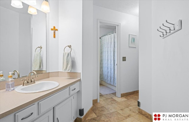 5517 S 174th Ave, Omaha, NE 68135 - bathroom with baseboards, vanity, and stone finish flooring