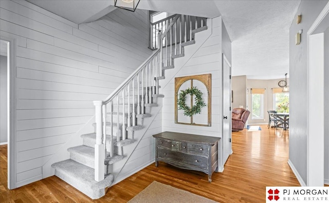 5517 S 174th Ave, Omaha, NE 68135 - stairway featuring wood finished floors, wooden walls, and baseboards