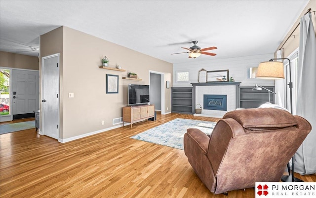 5517 S 174th Ave, Omaha, NE 68135 - living room featuring baseboards, light wood finished floors, a ceiling fan, and a fireplace