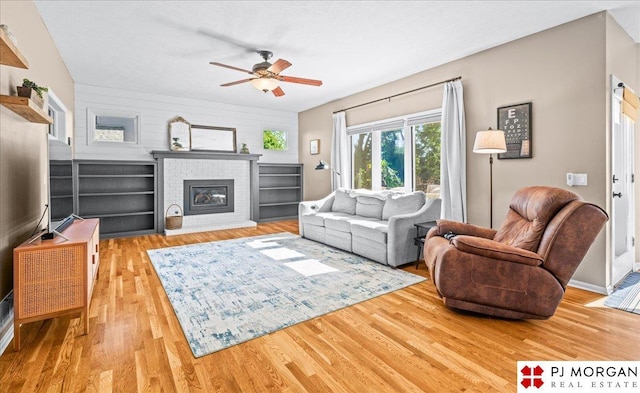 5517 S 174th Ave, Omaha, NE 68135 - living area with wood finished floors, ceiling fan, a fireplace, and baseboards