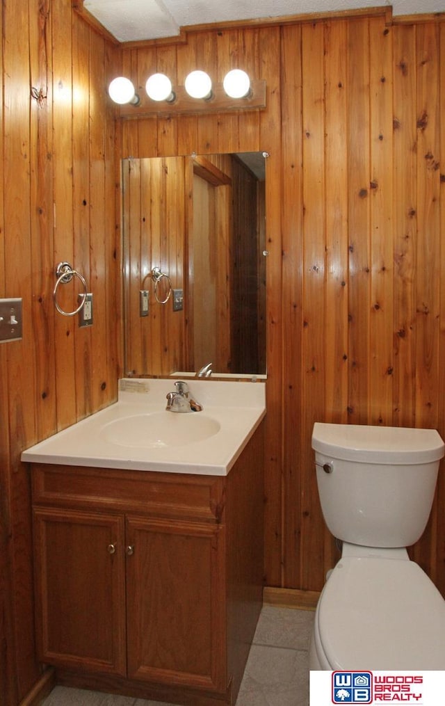 1912 SW 25th St, Lincoln, NE 68522 - bathroom with vanity, wooden walls, toilet, and tile patterned flooring