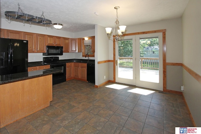 1912 SW 25th St, Lincoln, NE 68522 - kitchen featuring black appliances, a chandelier, baseboards, brown cabinetry, and a sink