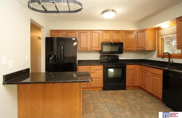 1912 SW 25th St, Lincoln, NE 68522 - kitchen with black appliances, a sink, dark stone countertops, a peninsula, and brown cabinets