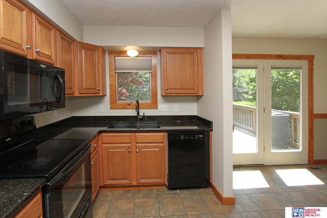 1912 SW 25th St, Lincoln, NE 68522 - kitchen with black appliances, a sink, brown cabinets, and dark stone countertops