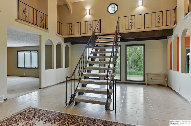 2564 County Road 12, Fremont, NE 68025 - staircase featuring a high ceiling, tile patterned floors, carpet flooring, and baseboards