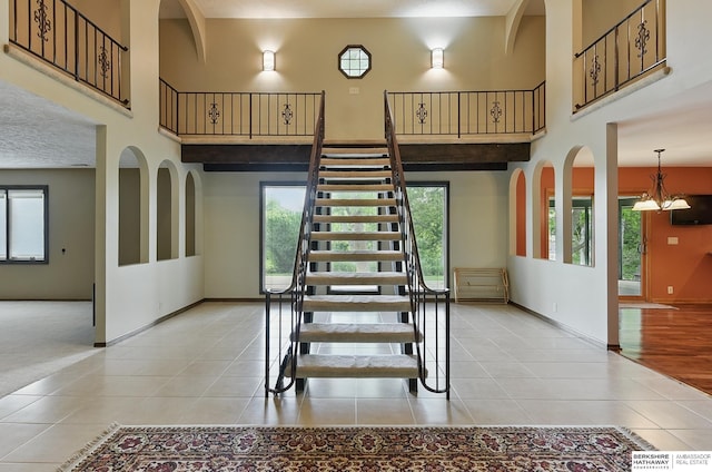 2564 County Road 12, Fremont, NE 68025 - stairs with a high ceiling, tile patterned flooring, baseboards, healthy amount of natural light, and a chandelier