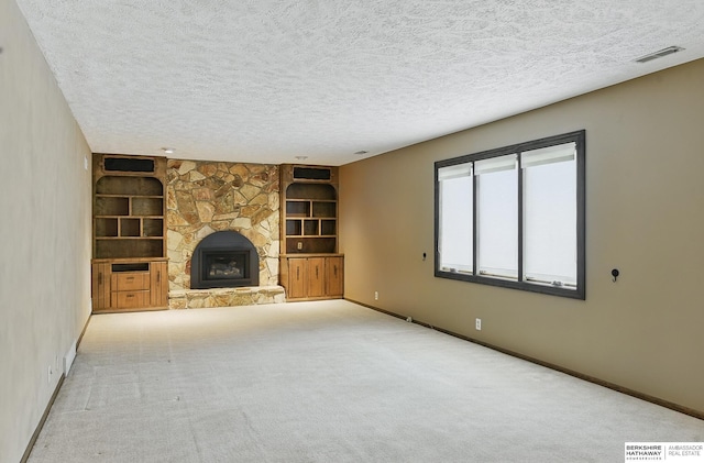 2564 County Road 12, Fremont, NE 68025 - unfurnished living room featuring built in features, baseboards, a textured ceiling, a fireplace, and carpet