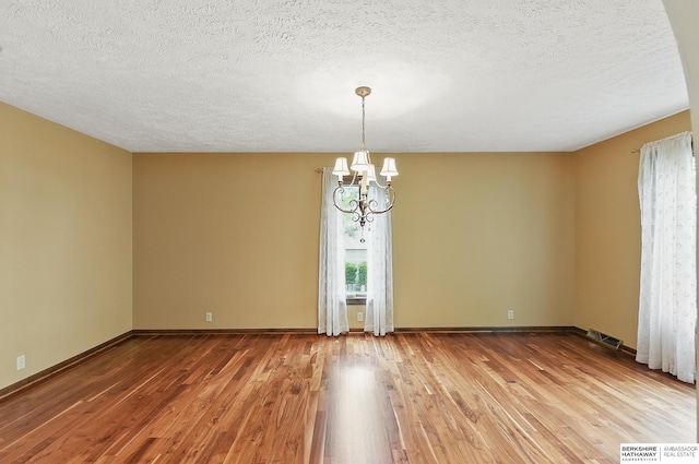 2564 County Road 12, Fremont, NE 68025 - spare room featuring a chandelier, wood finished floors, a textured ceiling, and baseboards
