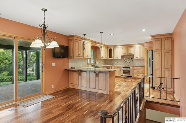 2564 County Road 12, Fremont, NE 68025 - kitchen featuring stainless steel appliances, a peninsula, a sink, wood finished floors, and baseboards