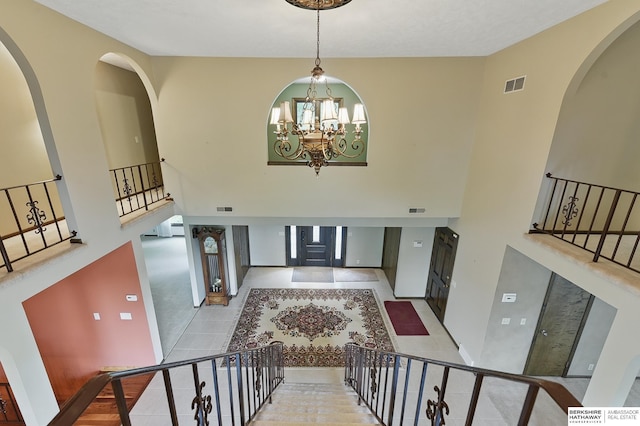 2564 County Road 12, Fremont, NE 68025 - tiled foyer entrance with a towering ceiling, stairway, a chandelier, and arched walkways