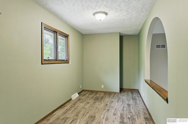 2564 County Road 12, Fremont, NE 68025 - unfurnished room featuring a textured ceiling, wood finished floors, arched walkways, and baseboards