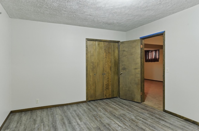 2564 County Road 12, Fremont, NE 68025 - unfurnished bedroom with wood finished floors, a textured ceiling, baseboards, and a closet