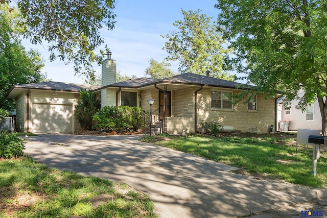 700 S 51st St, Lincoln, NE 68510 - ranch-style house featuring a garage, stone siding, a chimney, and driveway